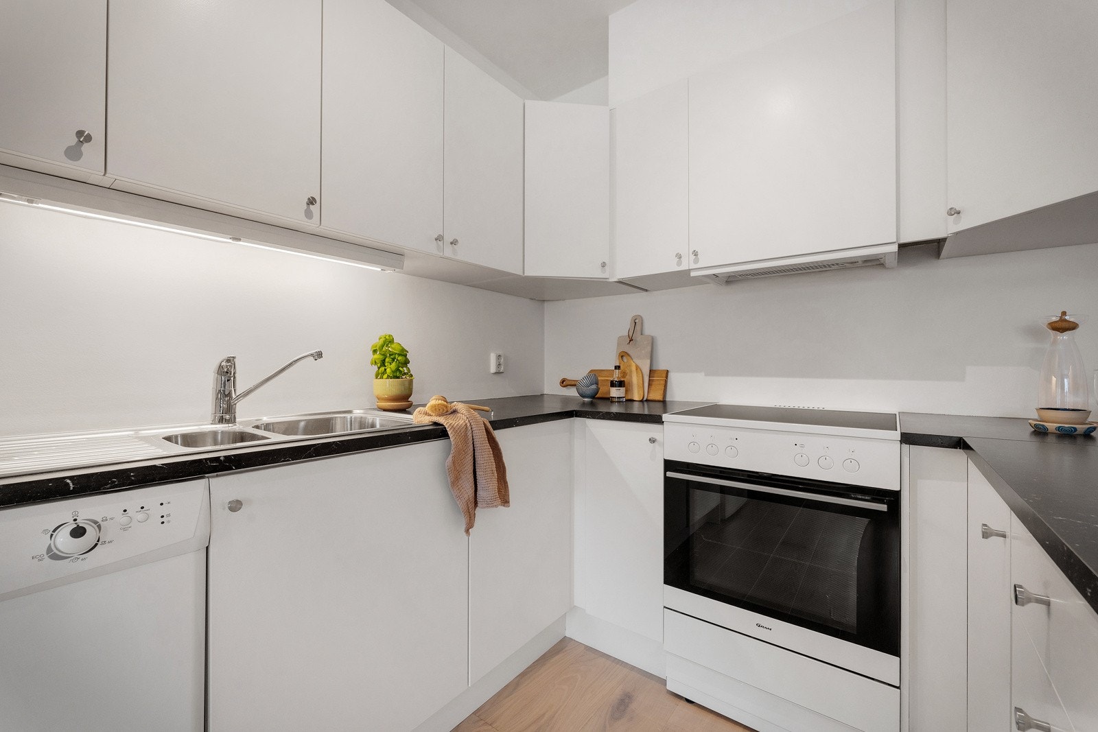 Kjøkkeninnredningen er tidløs med hvite slette fronter og laminat benkeplate. Den gode utformingen sørger for godt med skap- og benkeplass. Galleribilde