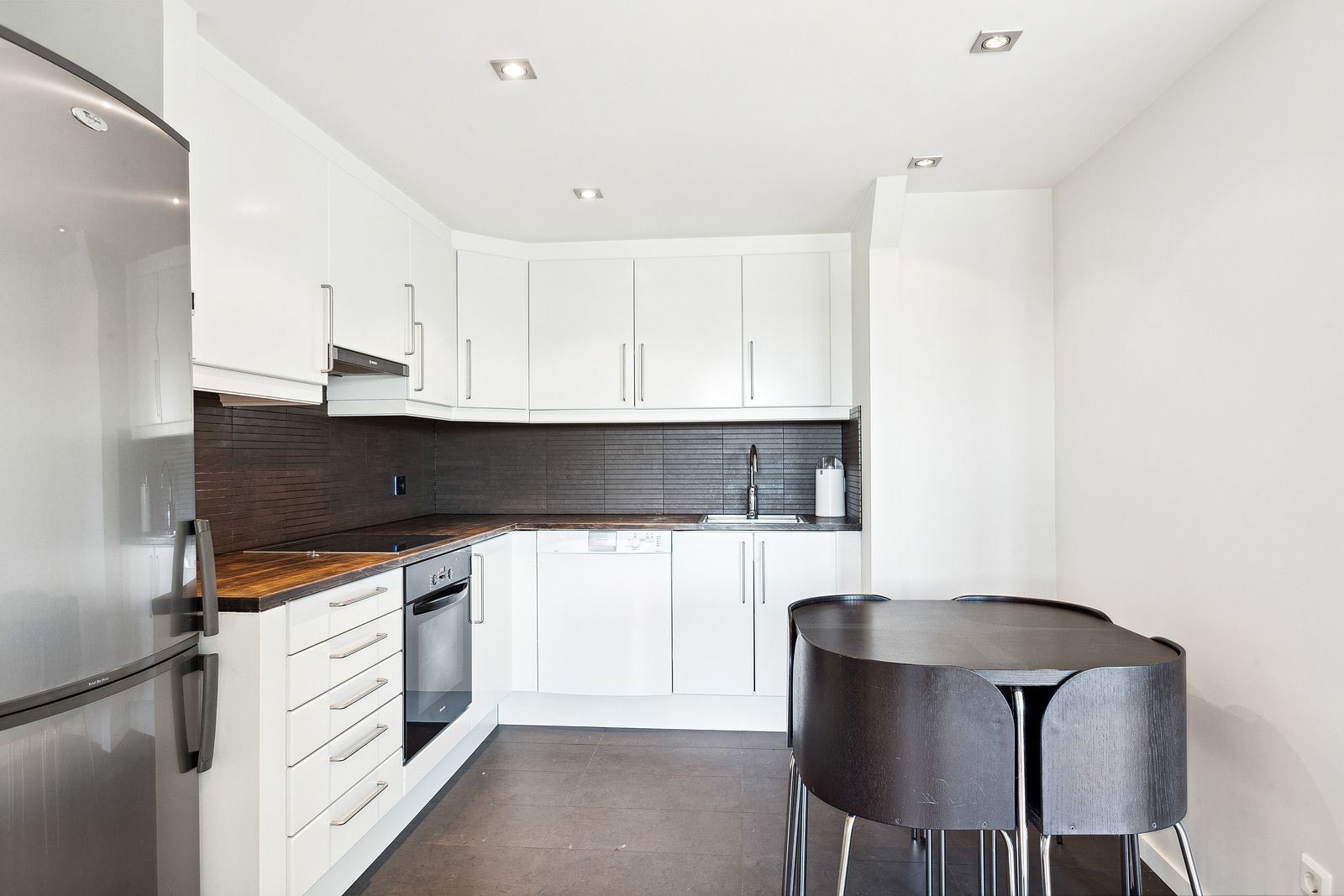 Åpen kjøkkenløsning med plass til spisebord - integrerte hvitevarer Galleribilde