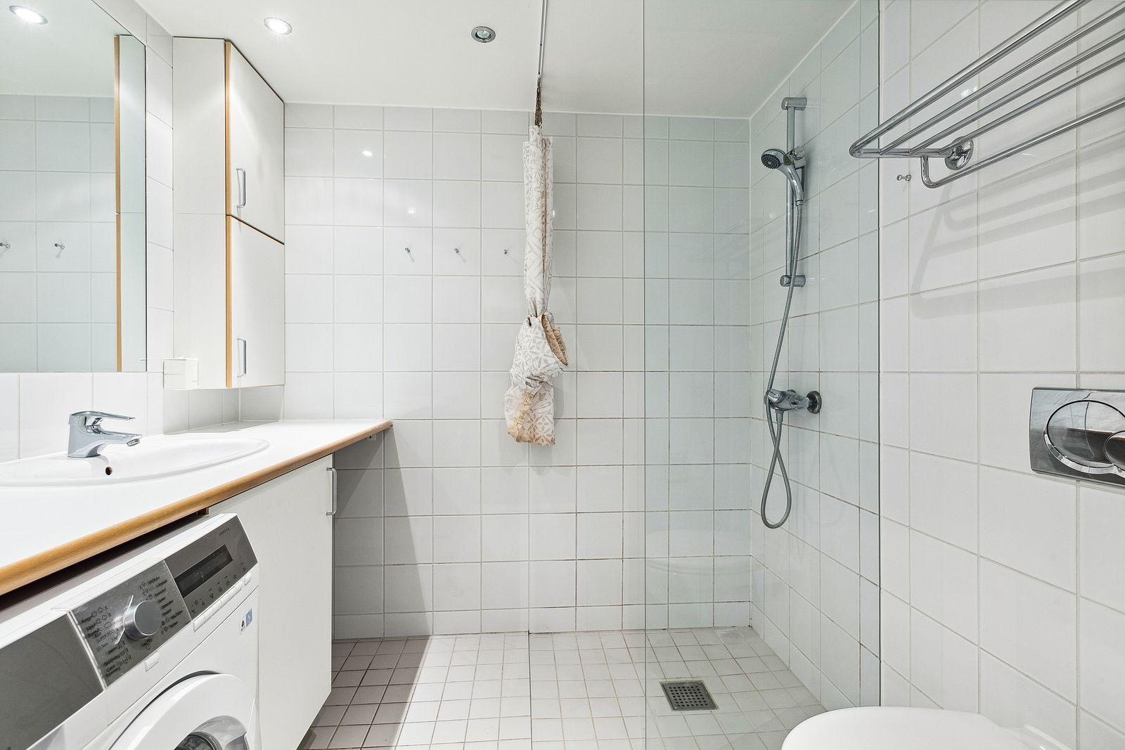 Hvitt flislagt baderom med vaskemaskin Galleribilde