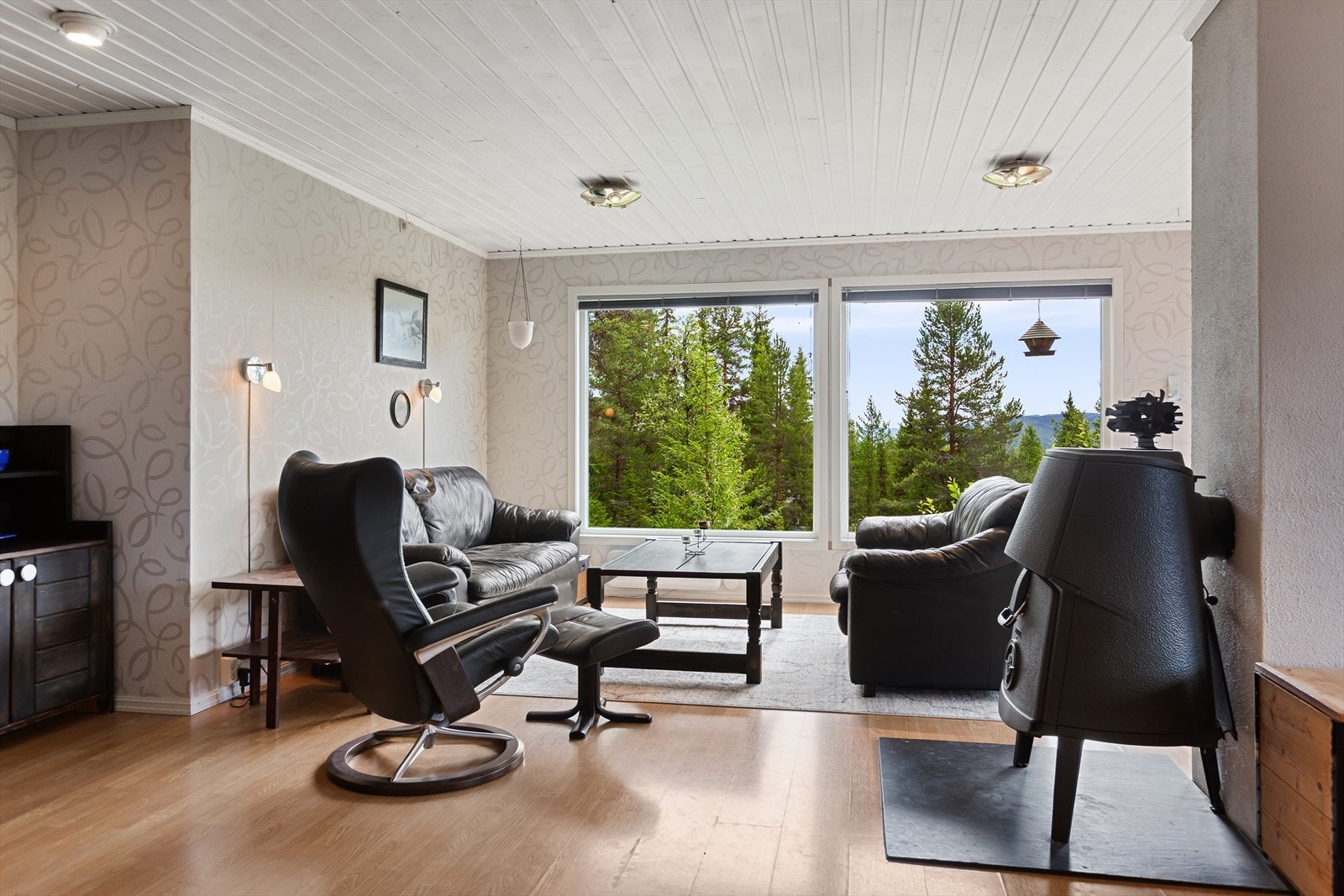 Fra gangen kommer man inn til en romslig stue med store vindusflater som slipper inn godt med lys. Vinduene i 1. etasje ble byttet i 2022. Galleribilde