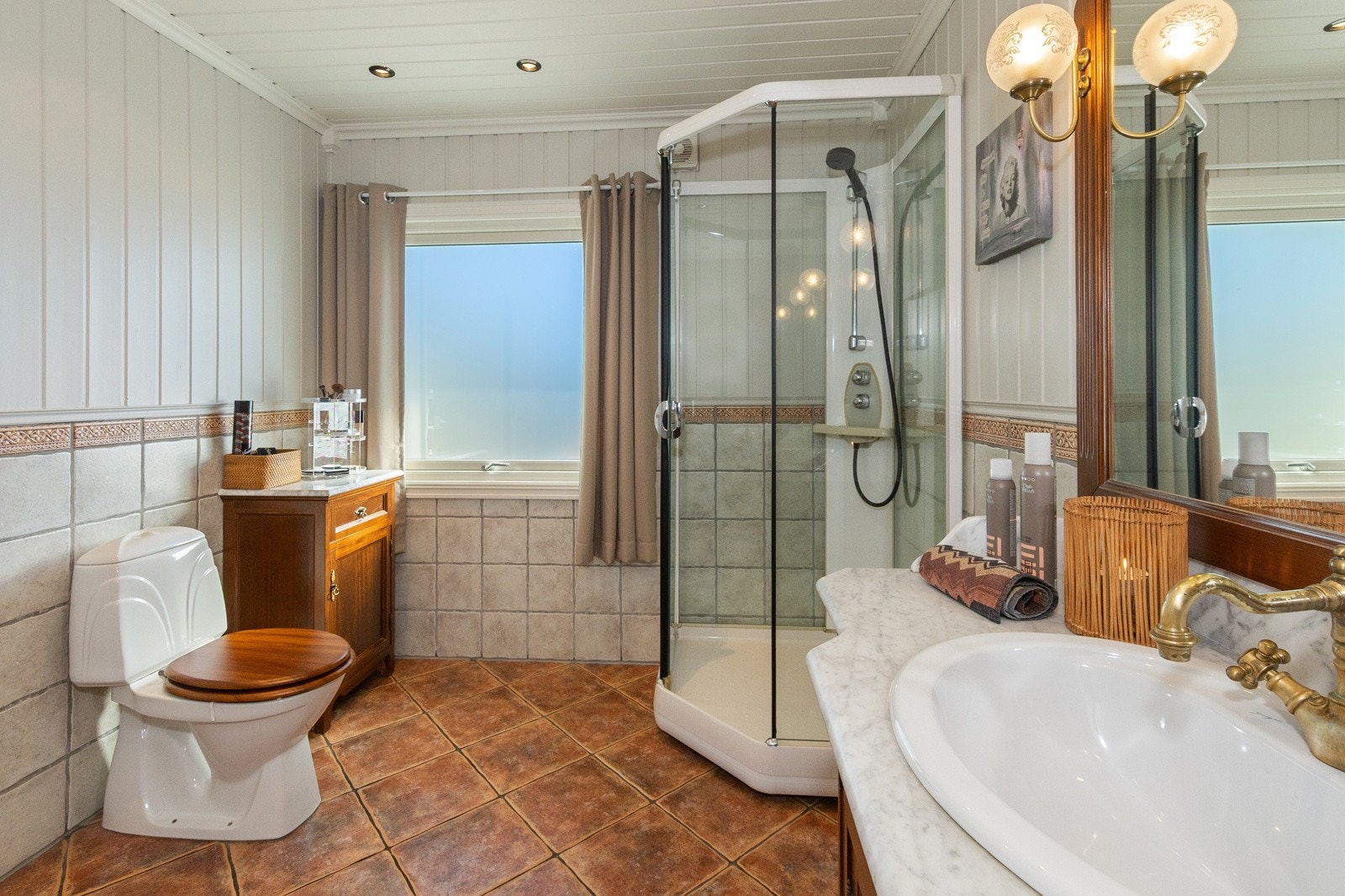 Dusjkabinett, servant i romslig innredning, høyskap, benkeskap samt toalett Galleribilde