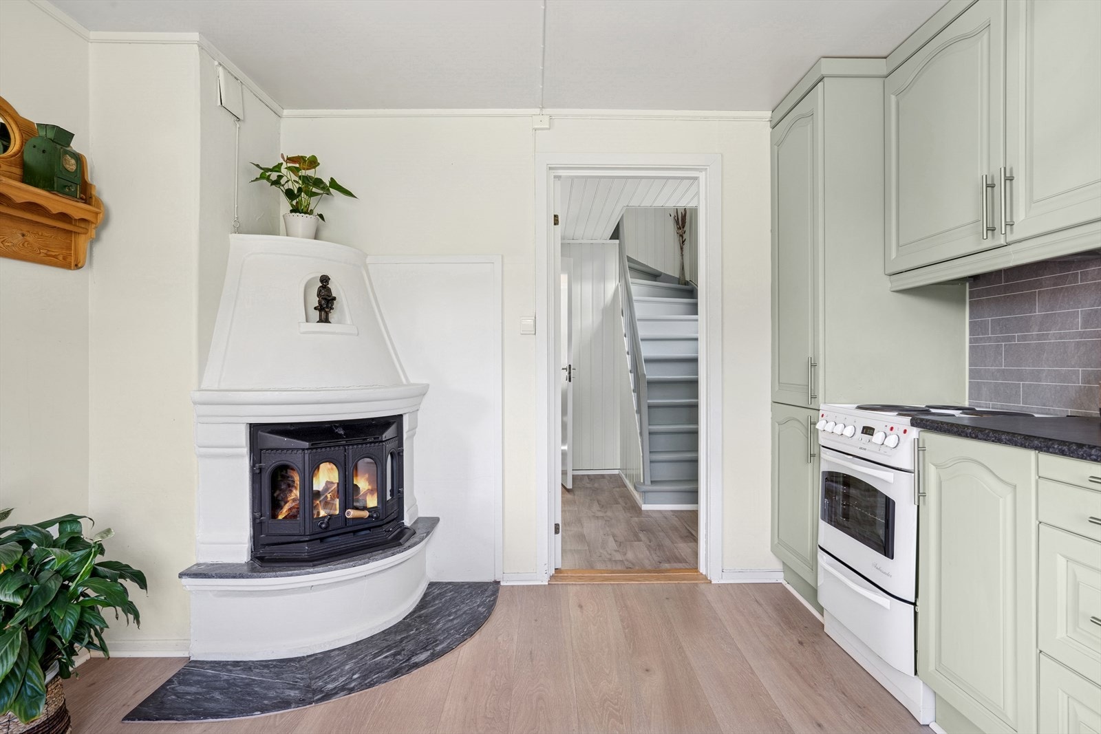 Et lunt og innbydende kjøkken der peisovnen skaper både varme og atmosfære, perfekt for rolige morgener. Galleribilde