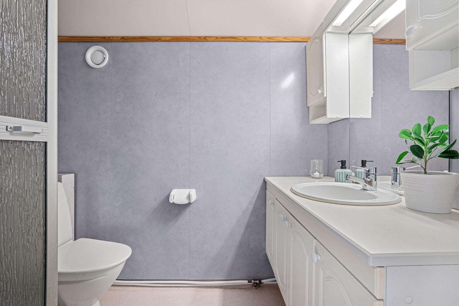 Flislagt baderom fra 2017 med varmekabler i gulv. Utstyrt med gulvmontert toalett, servant med servantskap, speilskap og dusjhjørne med glassdører. Galleribilde