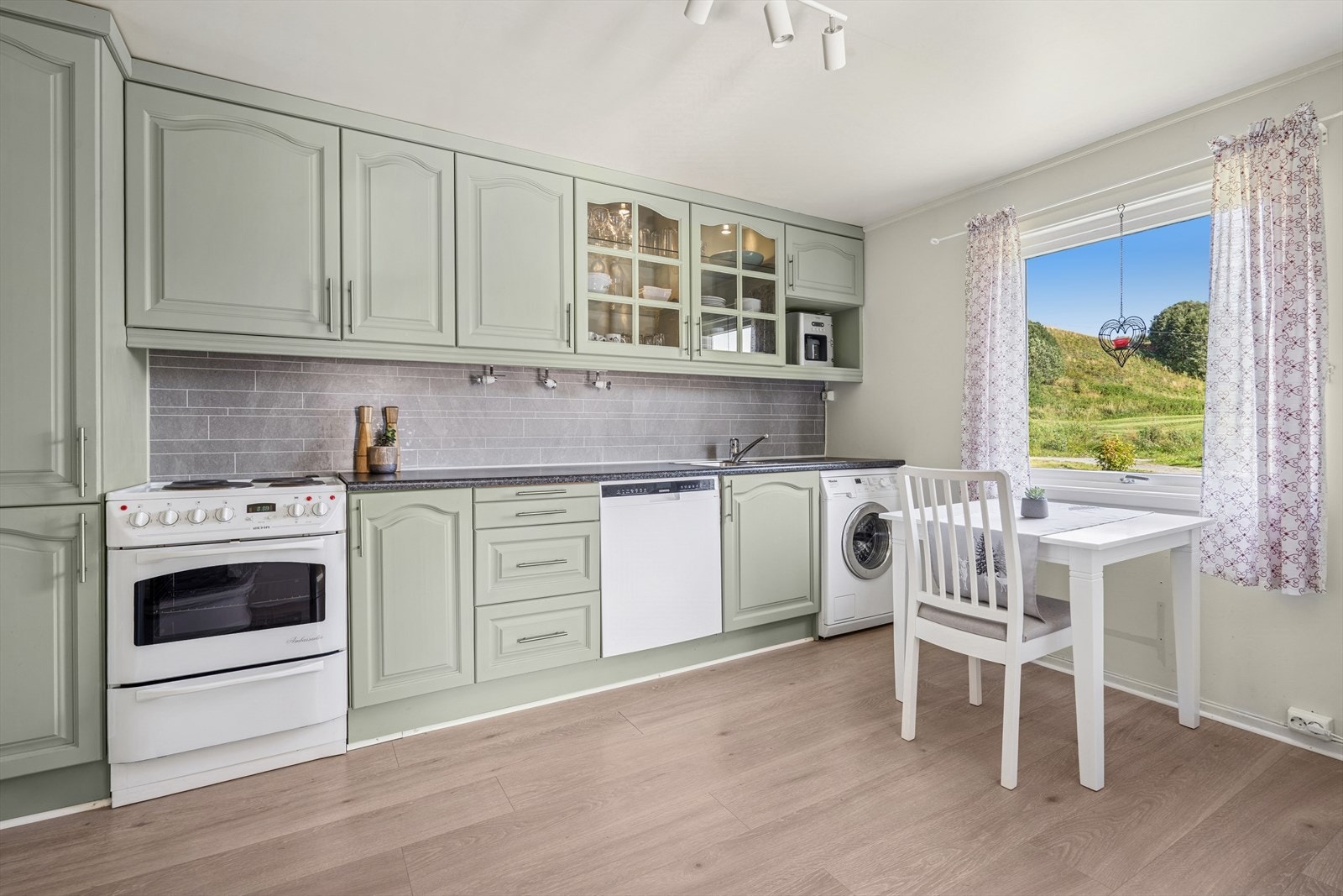 Pen kjøkkeninnredning fra 2017 med glatte fronter og laminat benkeplate. Galleribilde