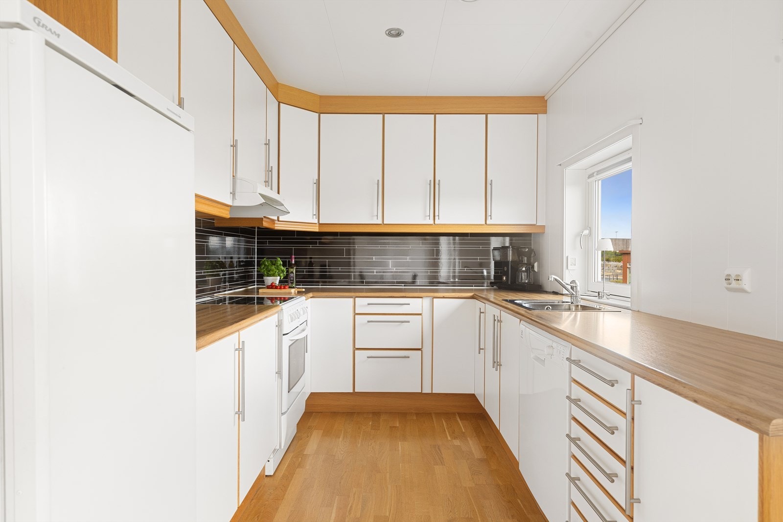 Romslig kjøkken hvor man har rikelig med skapplass til det meste en skulle ha behov for av både kopper og kar. Samtidig som man har nok benkeplass til å lage mat på. Galleribilde