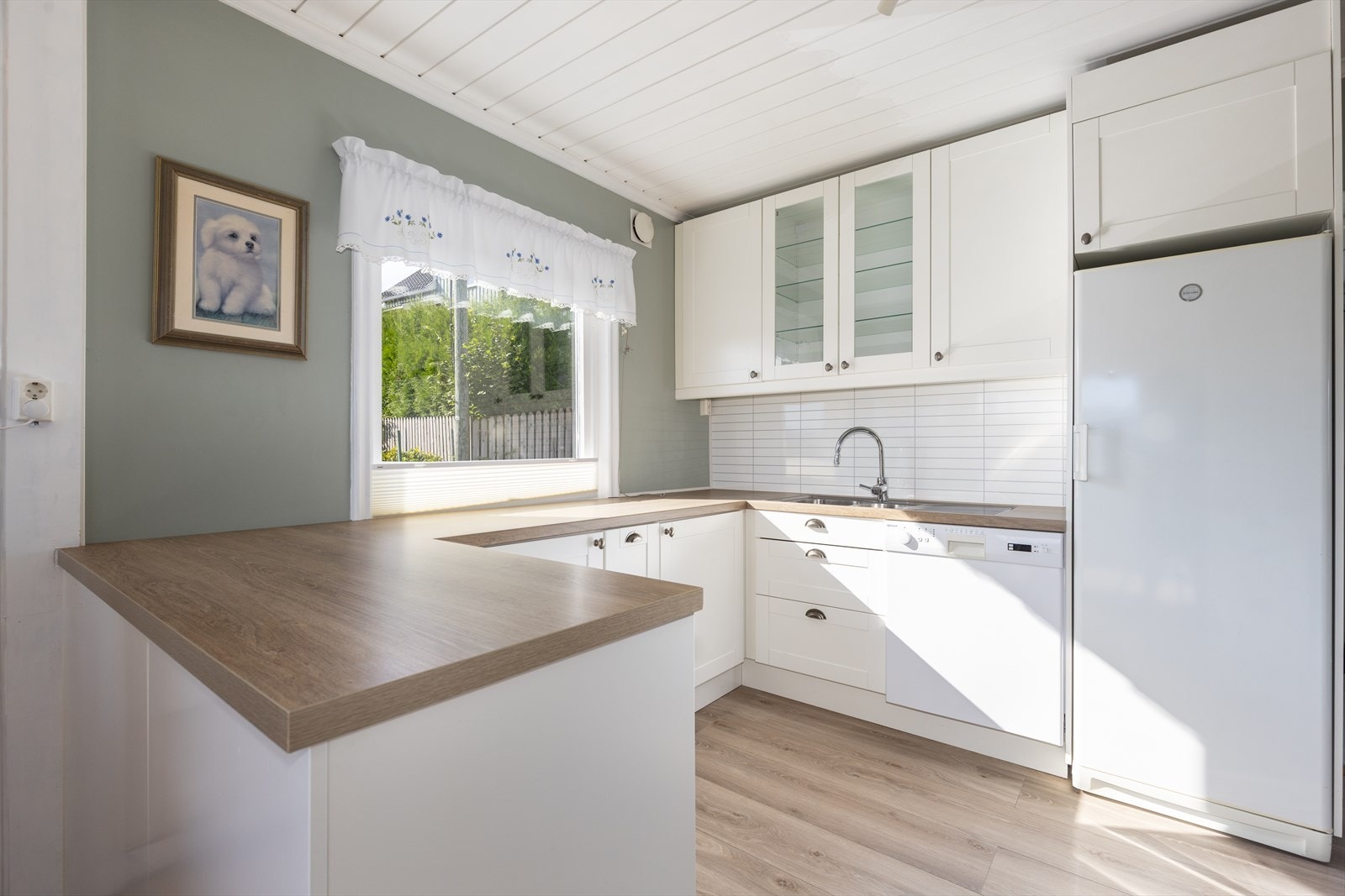 Lyst og pent kjøkken med profilert innredning og laminert bankeplate. God vindusflate med mye naturlys lys. Galleribilde