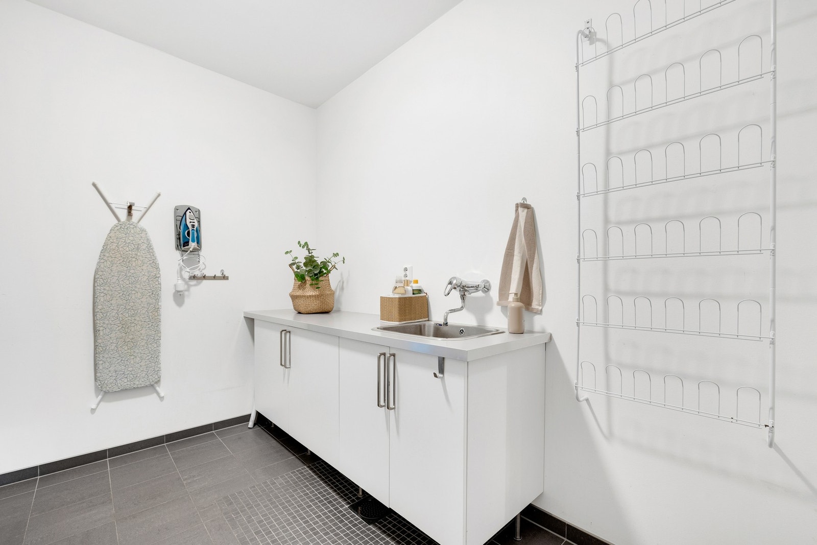 Benk til bretting av klær og oppbevaring av vaskeartikler, samt et praktisk vegghengt stativ. Galleribilde