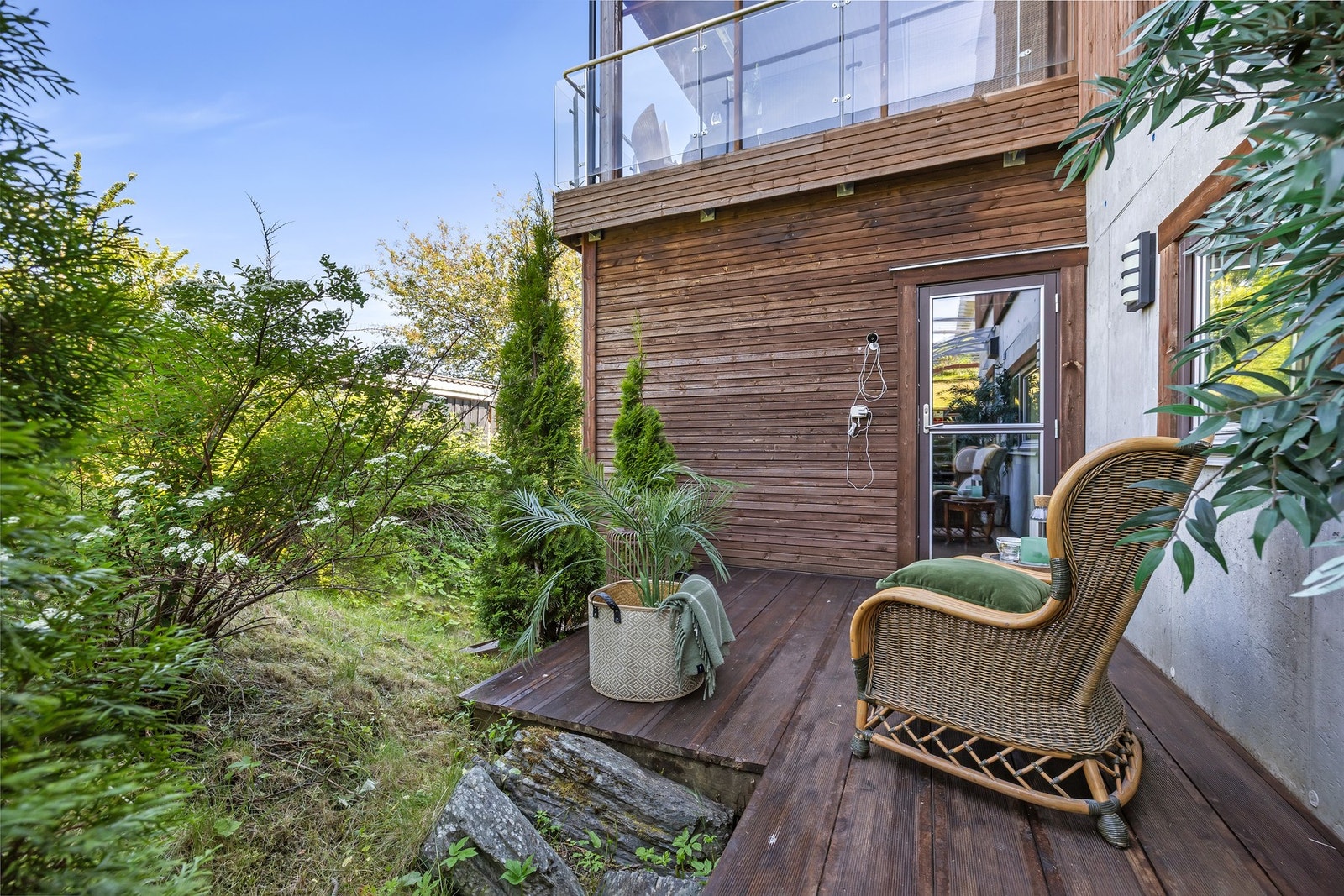 Eiendommen byr på en frodig og privat uteplass, med en trapp som strekker seg langs hele husets bakside og gjør det enkelt å bevege seg rundt hele boligen. Galleribilde