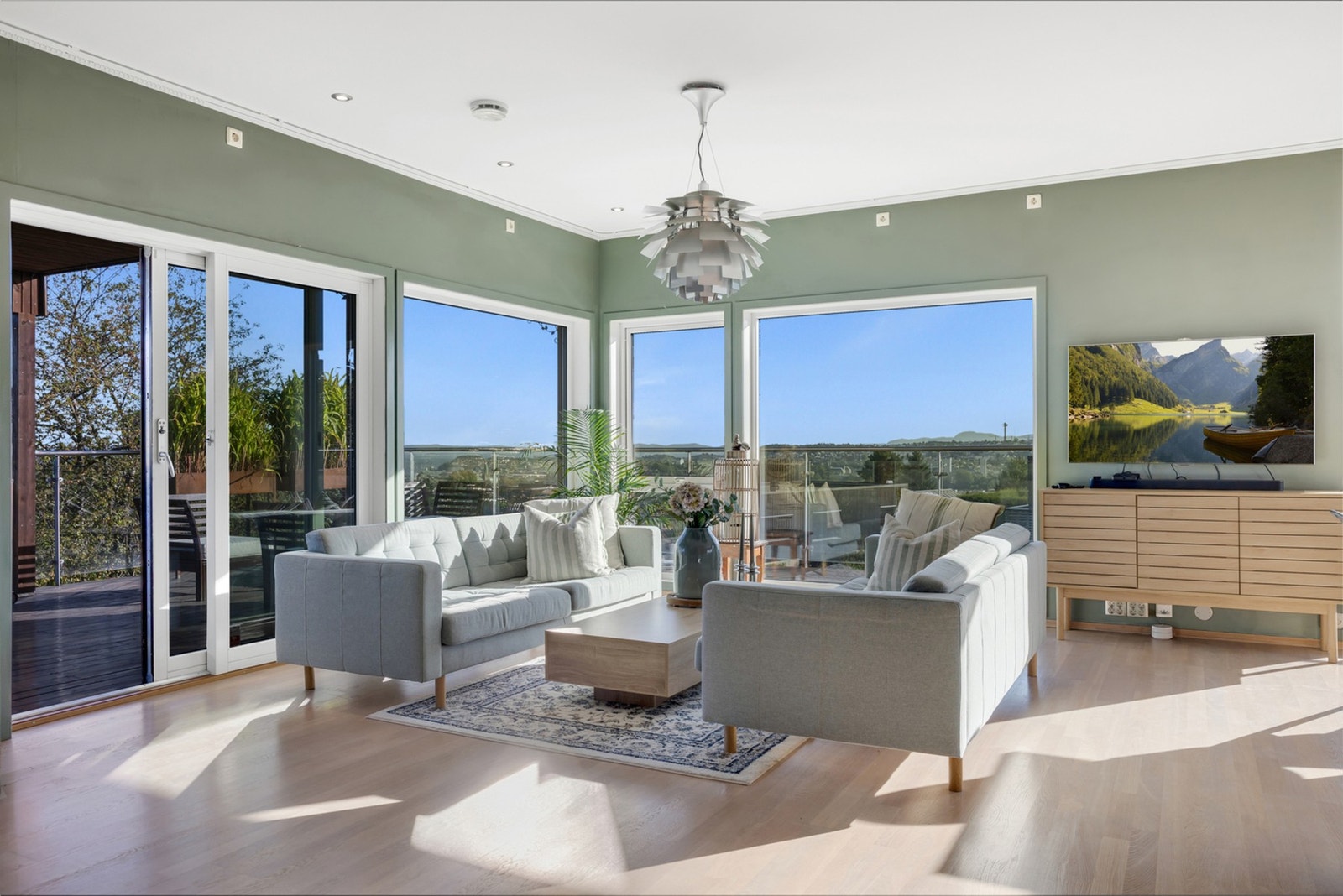 Stuen har utgang til veranda via to skyvedører, samt store vindusflater med god lysgjennomstrømming. Galleribilde