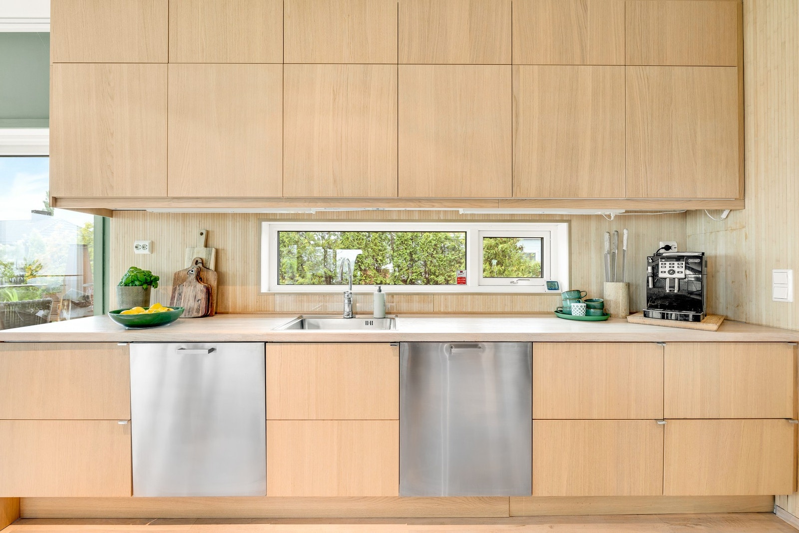 Rikelig oppbevaringsplass med skap helt opp til taket og to oppvaskmaskiner. Galleribilde