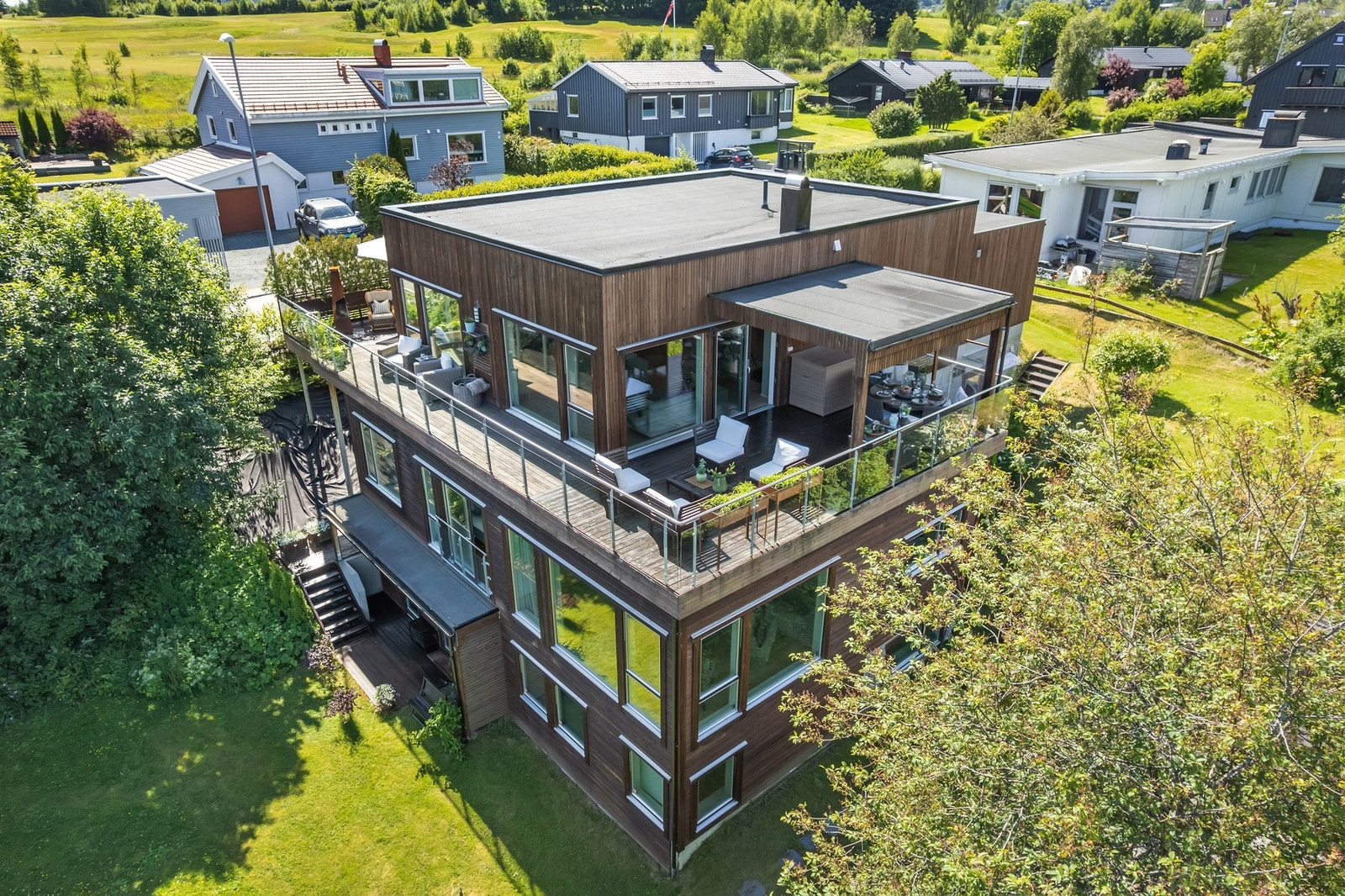 Boligen byr på tre innholdsrike etasjer, en stor garasje med elbillader, herlige uteplasser og en pent opparbeidet tomt. Galleribilde