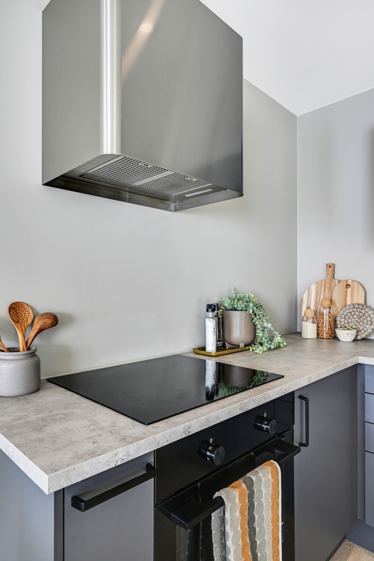 Stilig kjøkkenventilator, lysegrå kjøkken-innredning og laminat benkeplate. Galleribilde