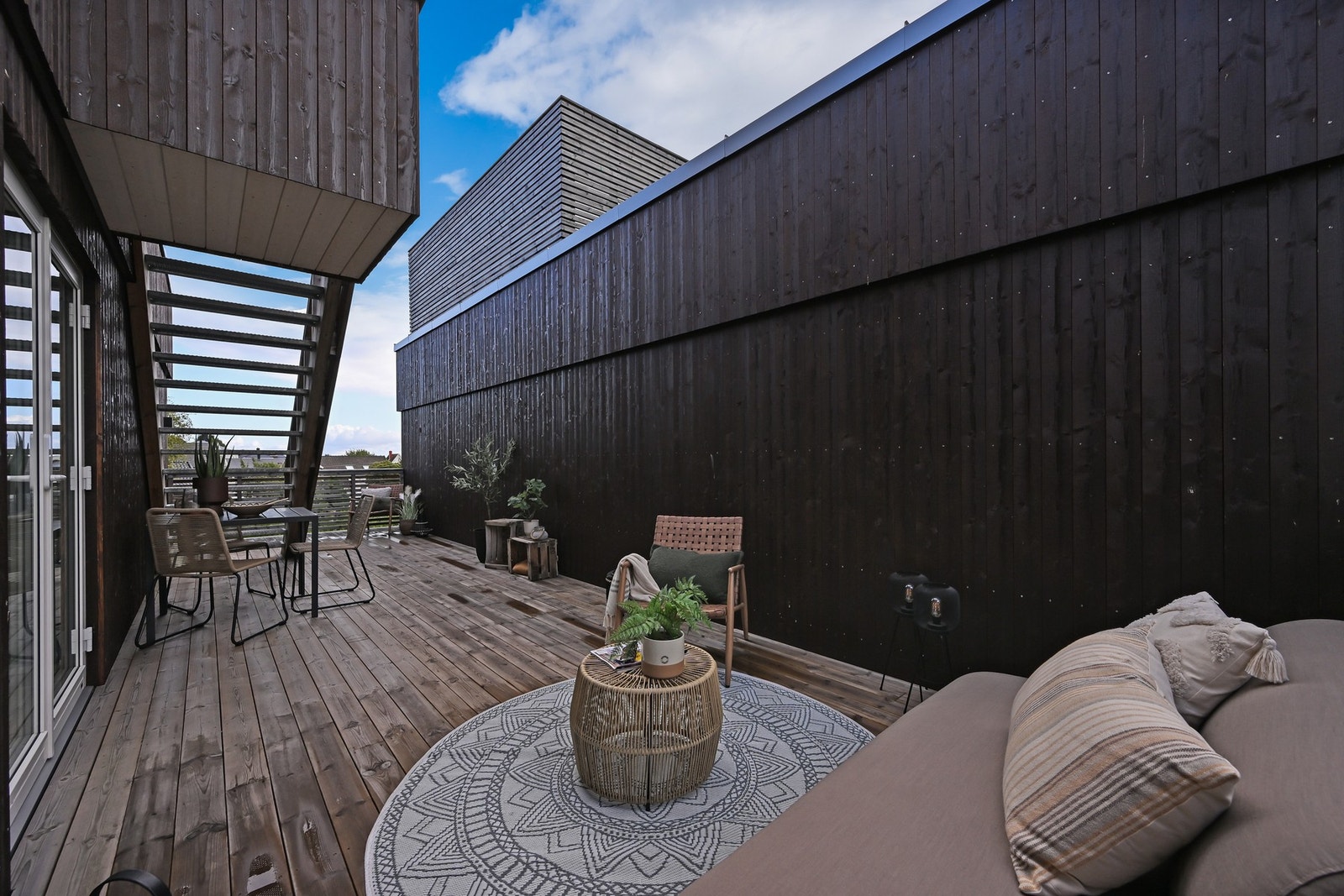 En usjenert og stor terrasse med dør fra stua. Galleribilde