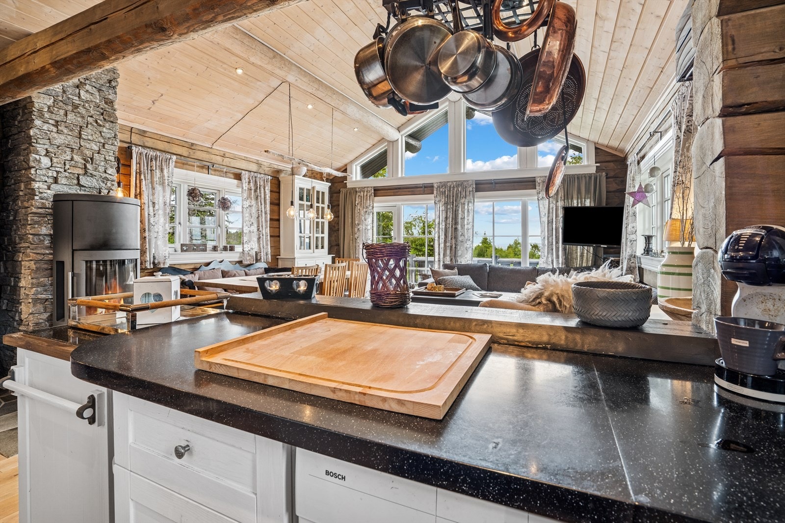 Det er en åpen stue- og kjøkkenløsning med store vindusflater som slipper inn rikelig med lys, samt gir god utsikt til de flotte omgivelsene rundt hytta Galleribilde