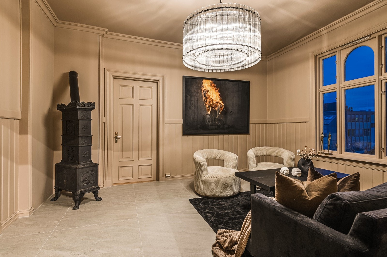 Romslig og tiltalende stue med god takhøyde og god plass til møblering. Stor designlampe i tak som preger rommet og gir det et ekslusivt uttrykk. Flott peisovn i hjørne. Flislagt gulv med grå 60x60 flis. Galleribilde