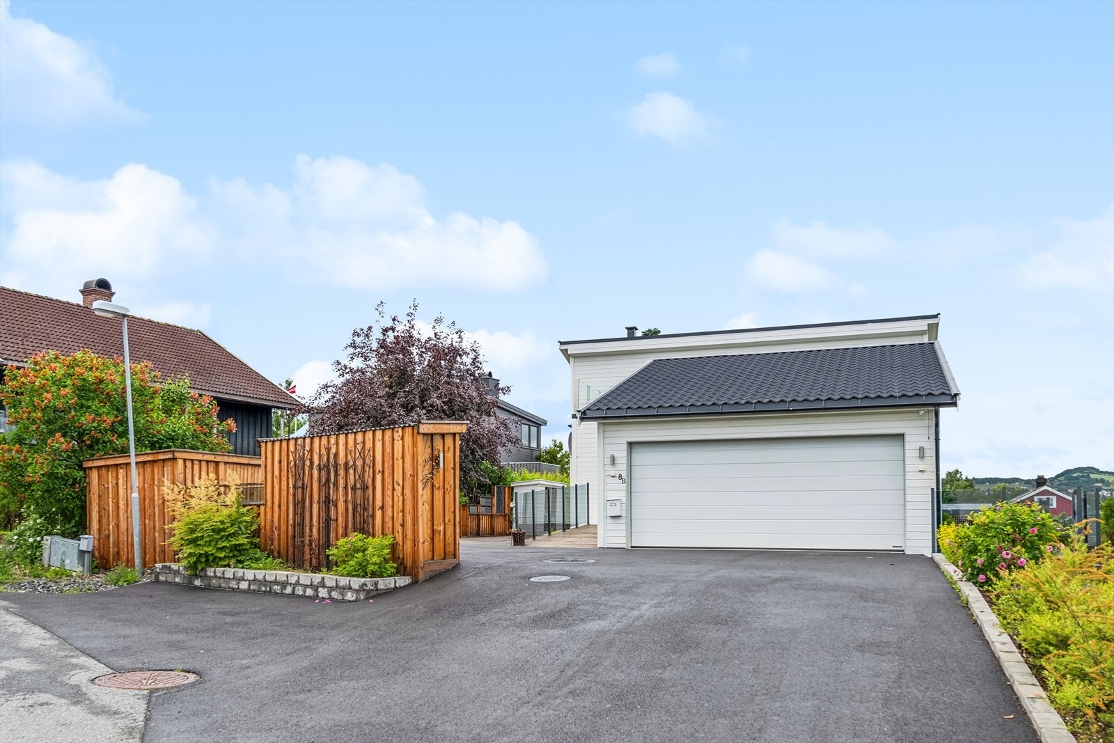 Eiendommen gir et positivt førsteinntrykk med sin asfalterte gårdsplass og fine beplantning. Galleribilde