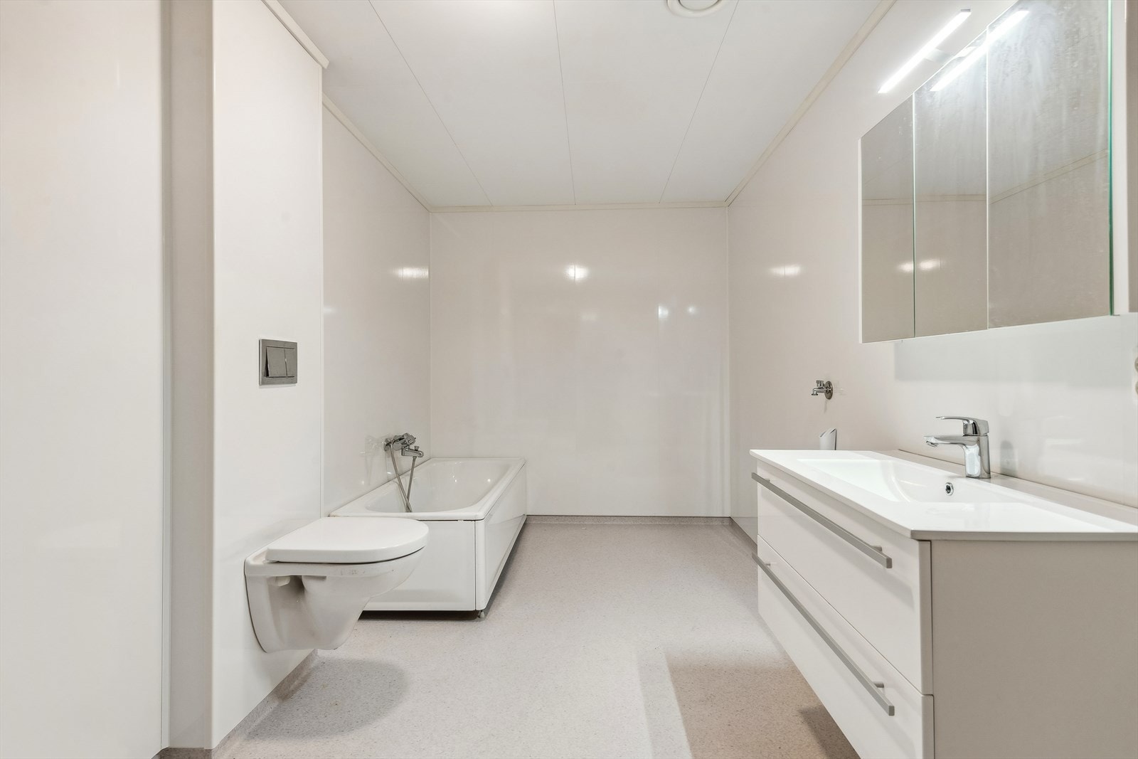 Innredningen har glatte hvite fronter med skuffer og heldekkende servant. Galleribilde