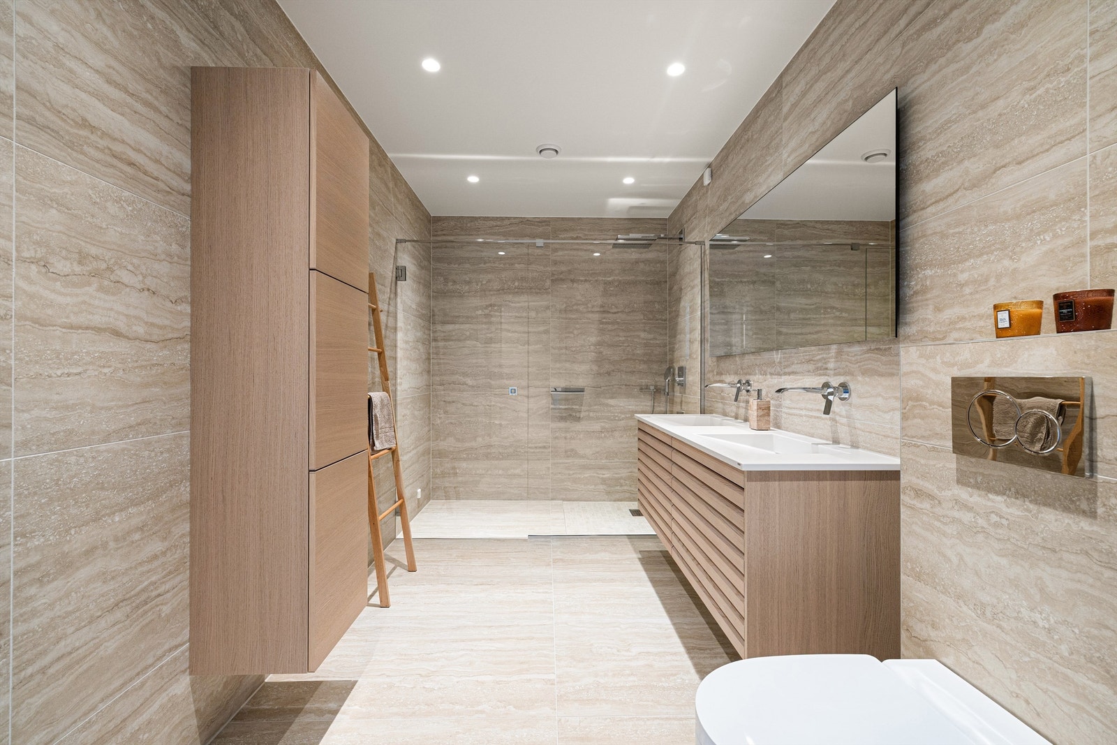 Begge bad er utstyrt med hver sin utpreget store dusjnisje. Armaturer innbygget i vegg fremmer et eksklusivt uttrykk. Galleribilde