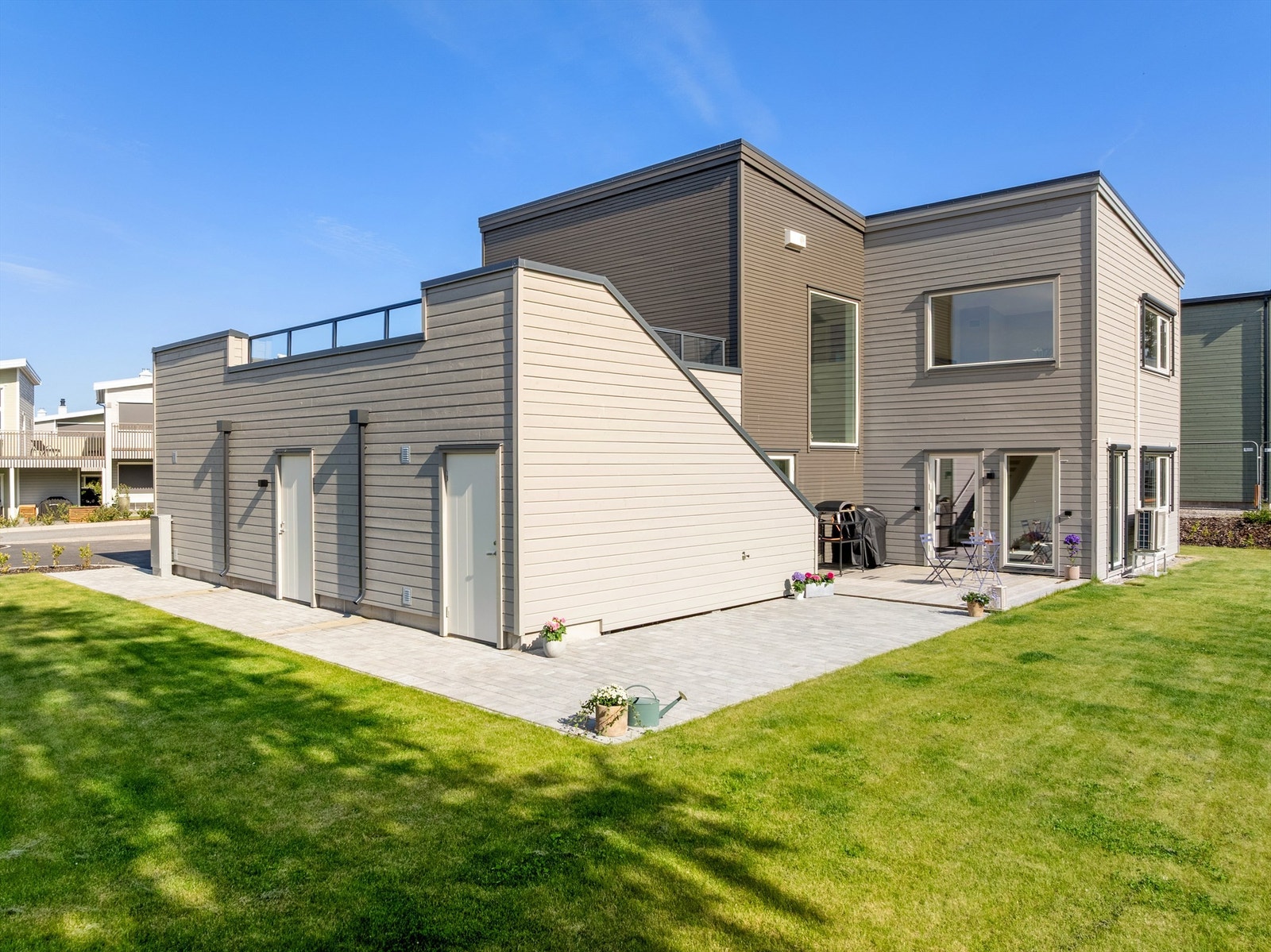 Gangareal utført helhetlig med belegningsstein leder frem til sportsbod og garasjedør. Galleribilde