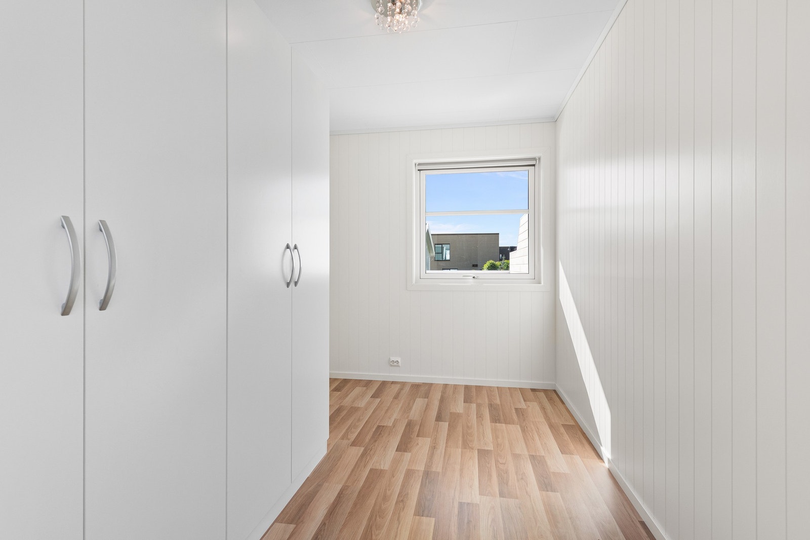 Soverom i 1. etasje med garderobeskap og vindu mot nabolaget. Galleribilde