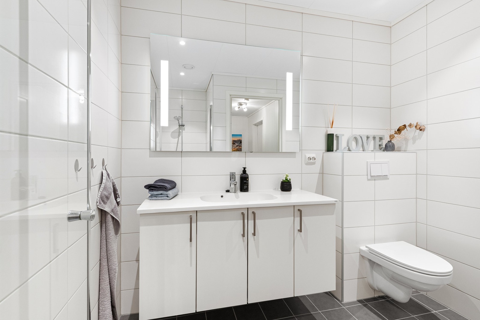 Badet har moderne innredning med speilskap og god oppbevaringsplass. Galleribilde