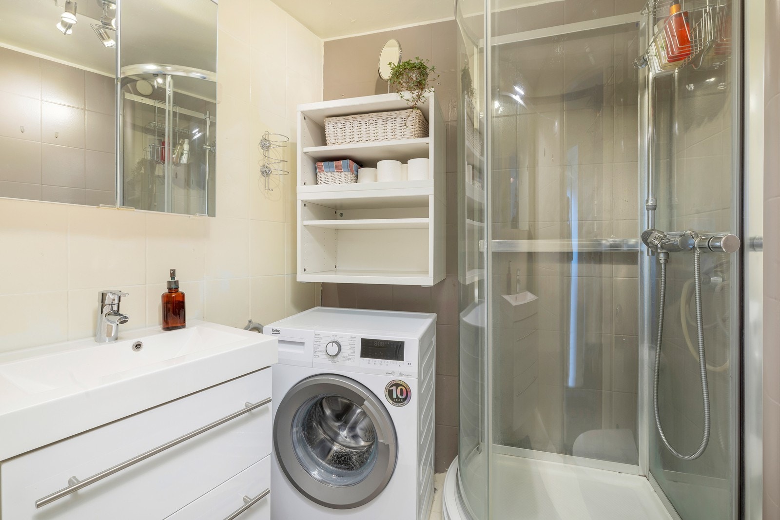 Flislagt bad med dusjkabinett, servant og toalett. Opplegg til vaskemaskin. Galleribilde