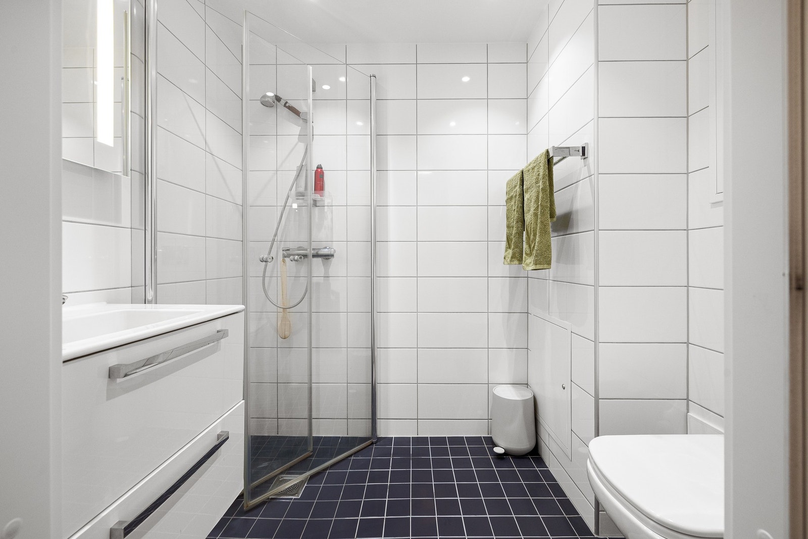Baderommet fremstår som stilrent og funksjonelt, med flislagte overflater og behagelige varmekabler i gulvet. Galleribilde
