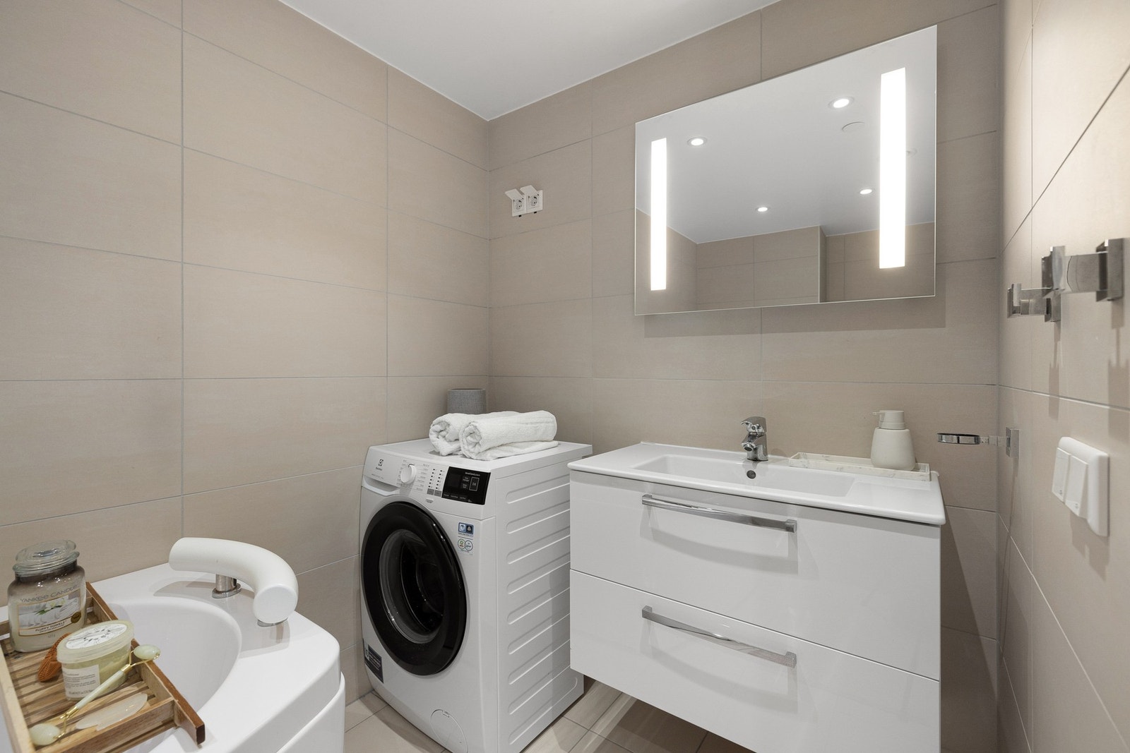 På badet er det lagt til rette for en praktisk hverdag med opplegg for både vaskemaskin og tørketrommel. Galleribilde