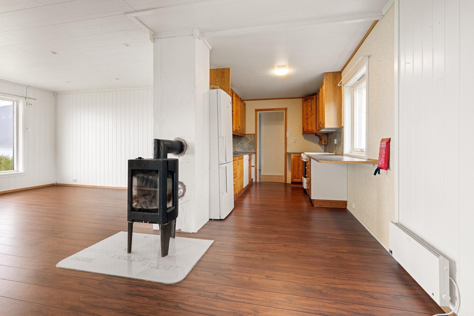 Stort kjøkken litt tilbaketrukket fra stue. Galleribilde