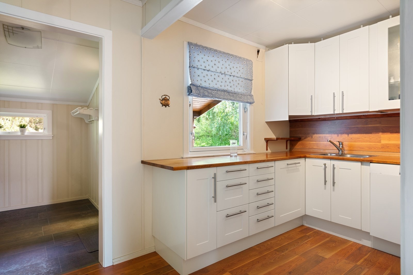 Integrerte hvitevarer med komfyr, koketopp og ventilator. Frittstående kjøle-/fryseskap. Innredningen har opplegg for oppvaskmaskin og det er montert kjøkkenventilator med avtrekk ut. Galleribilde