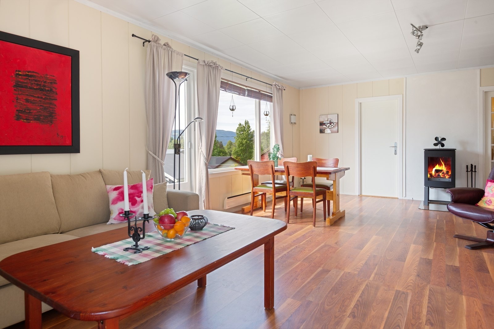 I stua er det fin plass til både sofa- og spisegruppe, og en stilig peisovn med innsyn gir lun og god varme til rommet. Galleribilde