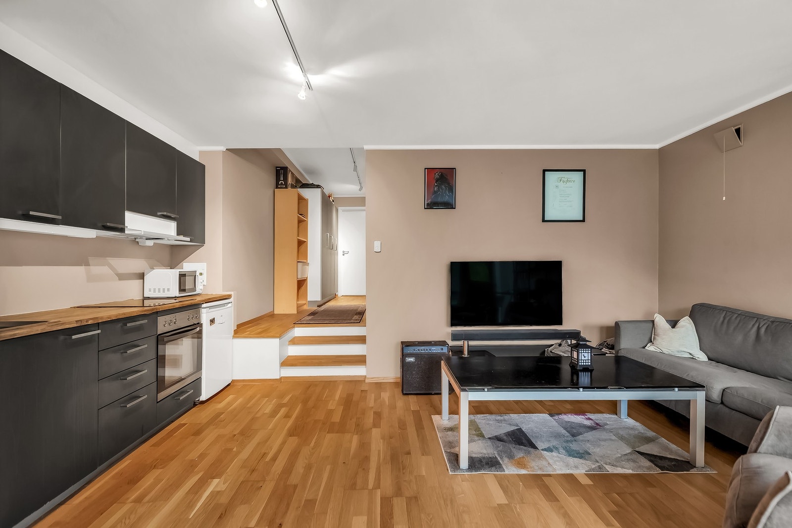 Langs den ene veggen er det kjøkken med moderne innredning. Galleribilde