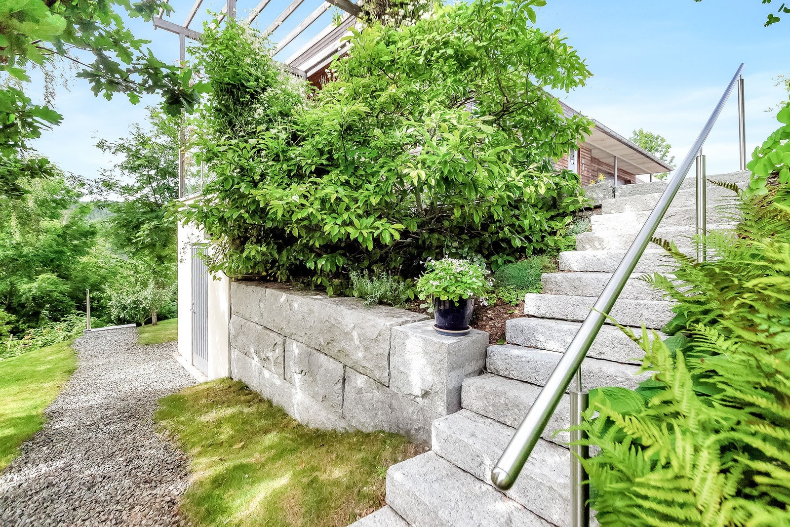 Det er frode blomsterbed rundt hele boligen. Utetrappene er i granitt og gir et moderne uttrykk. Galleribilde