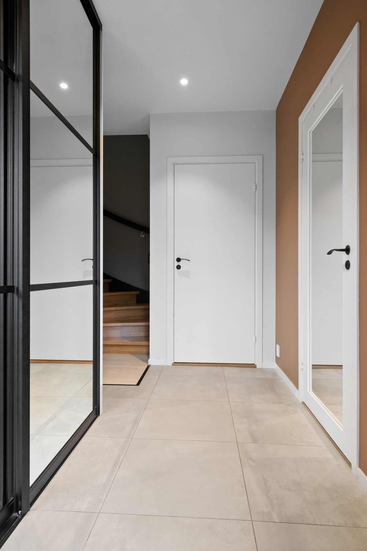 Entreen har store gulvfliser og slette vegger malt i tidsriktige farger. Galleribilde