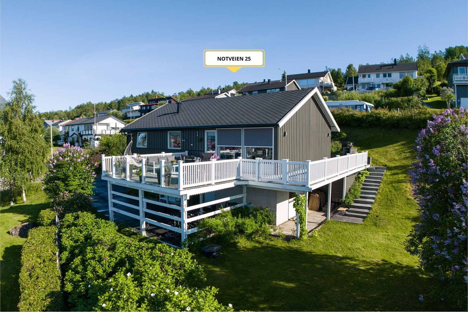 Eneboligen har stor veranda, flott hage, garasje og carport Galleribilde