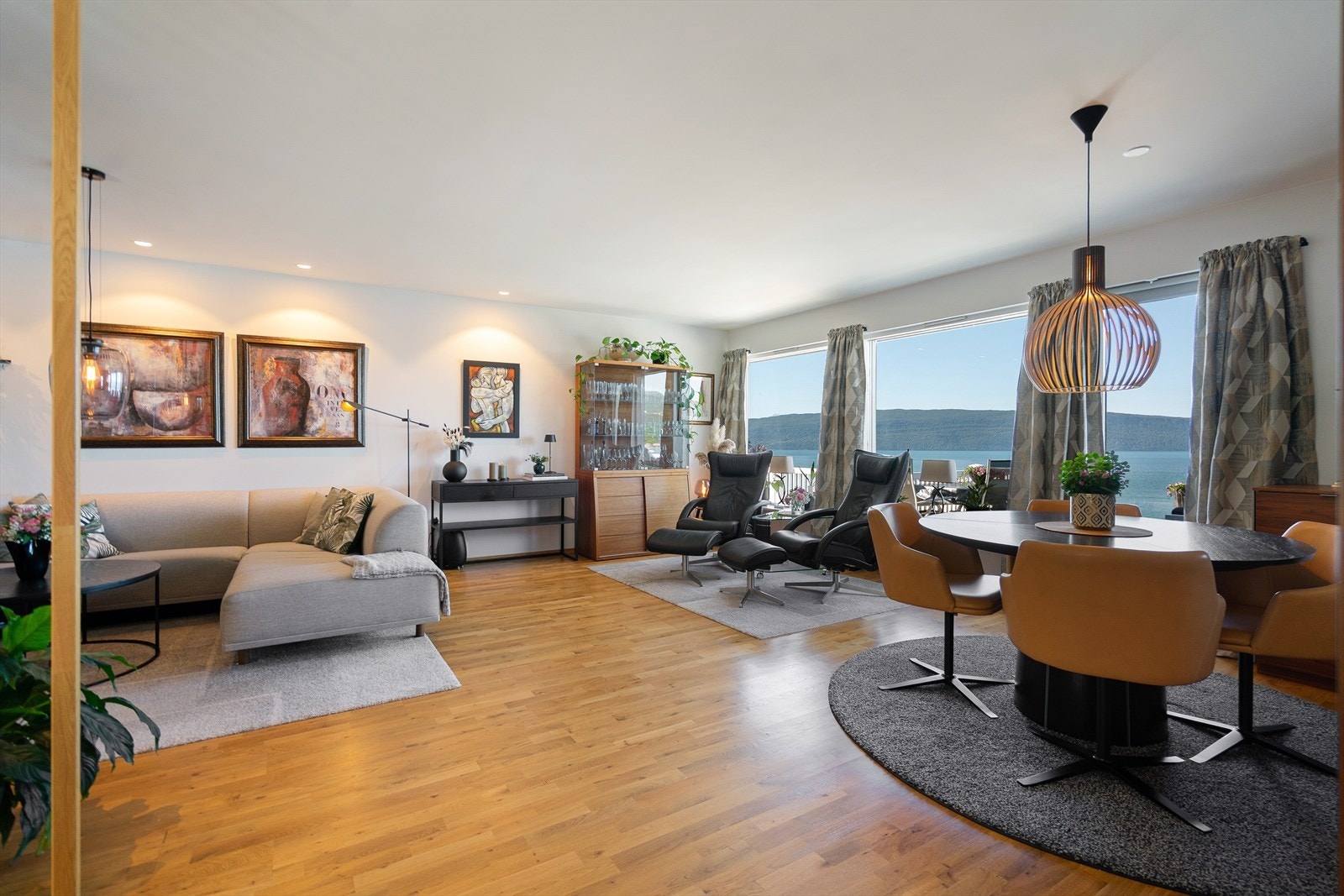 Romslig stue som gir god plass til både sofakrok, sittegruppe og spisebord Galleribilde