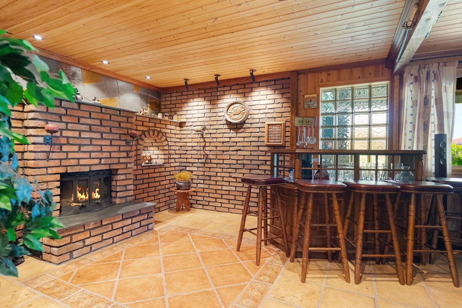 Koselig kjellerstue som er fliselagt og utstyrt med vedfyring Galleribilde