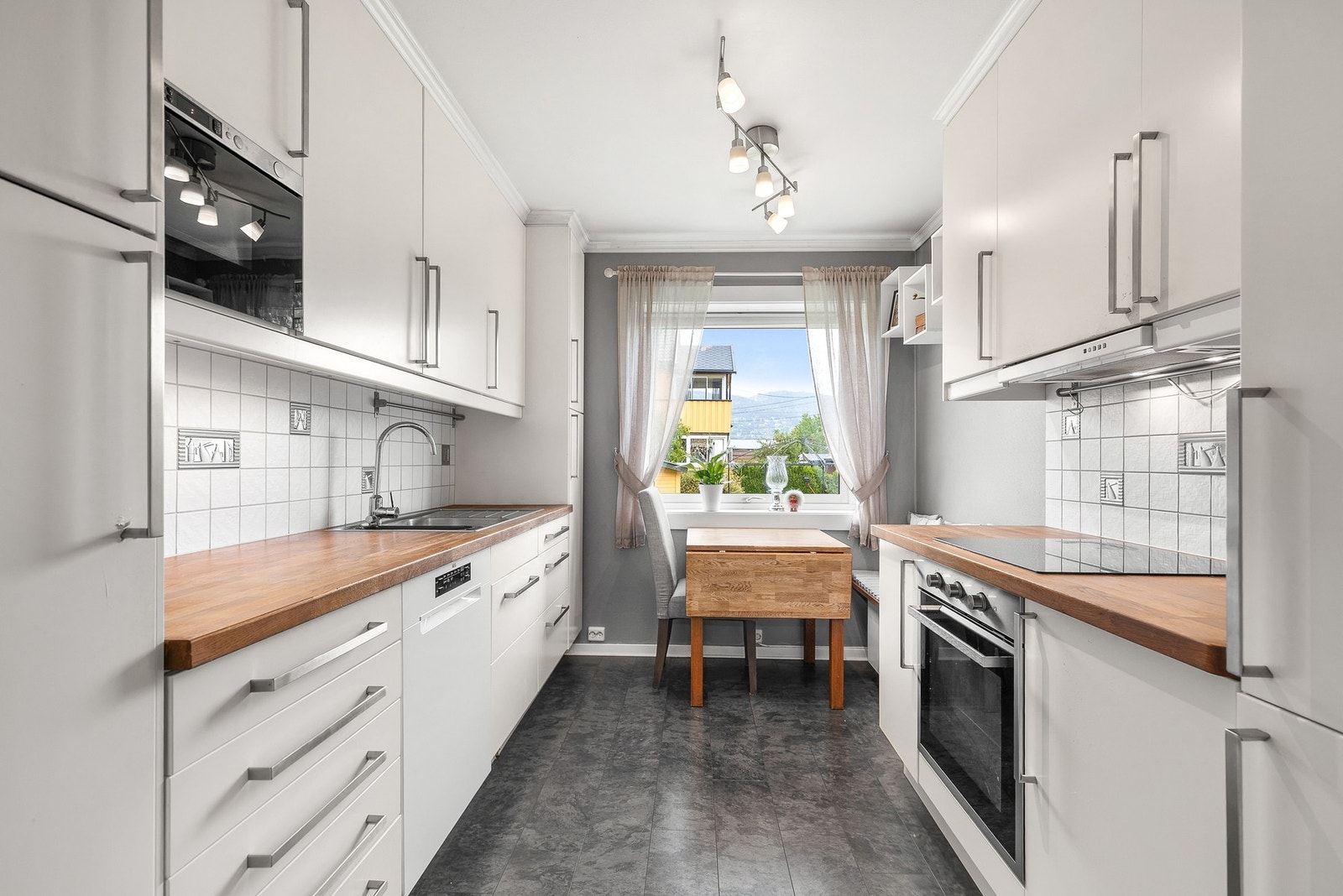 Kjøkkeninnredning med glatte fronter og benkeplate i heltre Galleribilde