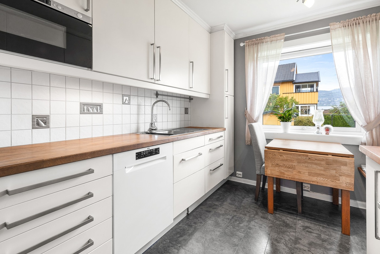 Det er integrert kjøl-/fryseskap, oppvaskmaskin, komfyr, mikrobølgeovn og platetopp Galleribilde