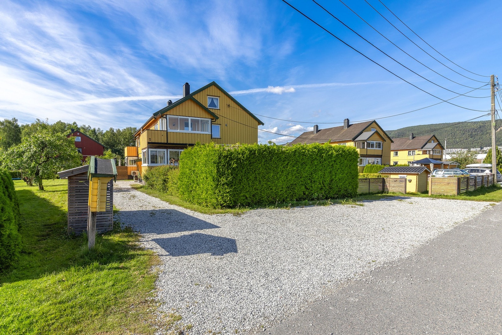 Parkering på biloppstillingsplasser i gruset gårdsplass utenfor leiligheten Galleribilde