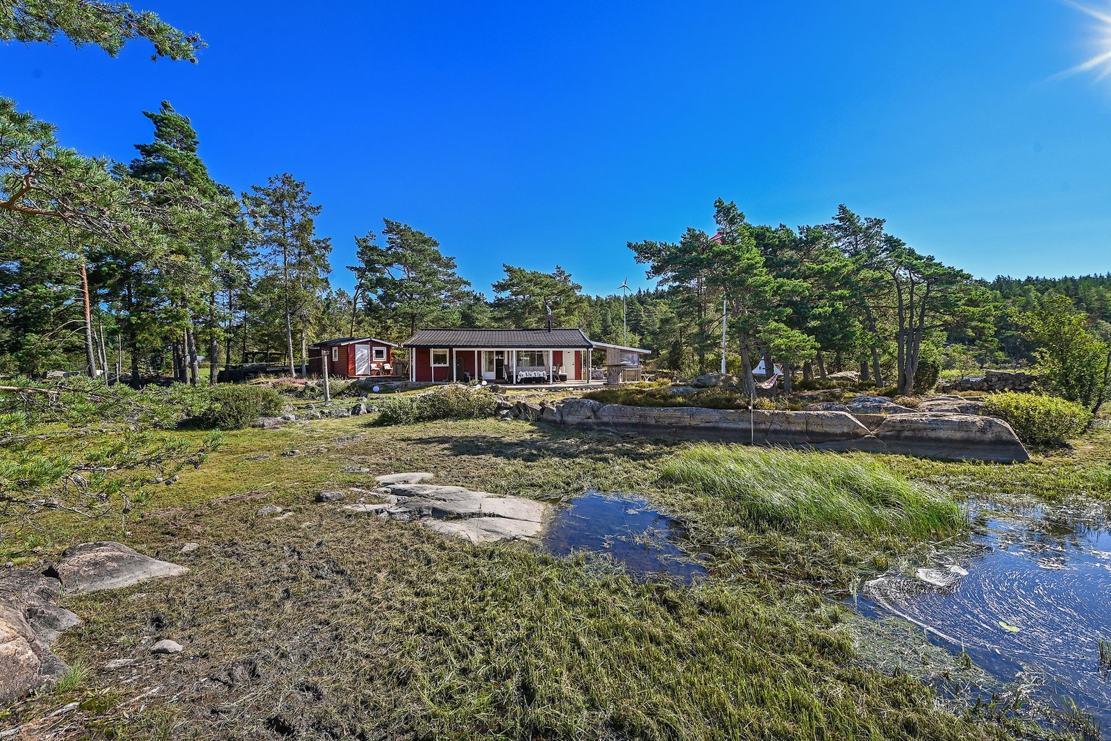 Hytta ligger skjermet til mellom trær. Galleribilde