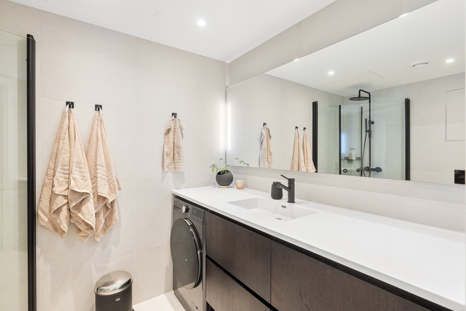 Badet er også svært praktisk, med opplegg og plass til vaskemaskin under benkeplaten - en løsning som ivaretar både funksjonalitet og estetikk. Galleribilde