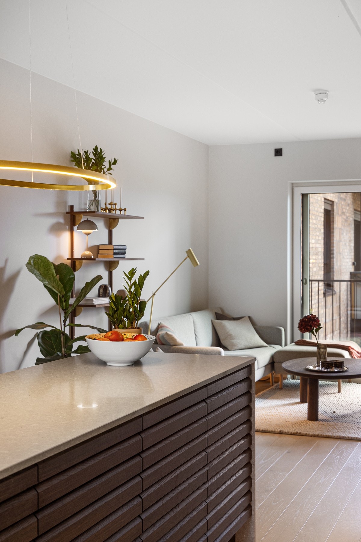 Den innbydende kjøkkenøyen er selve hjertet i rommet, med fronter i eik og en eksklusiv kompositt benkeplate som går sømløst ned til gulvet. Galleribilde