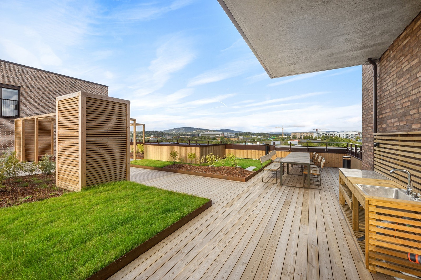 Fellesareal - Takterrassen er opparbeidet med grønn beplantning, soner for avslapping og hygge, samt utekjøkken. Galleribilde