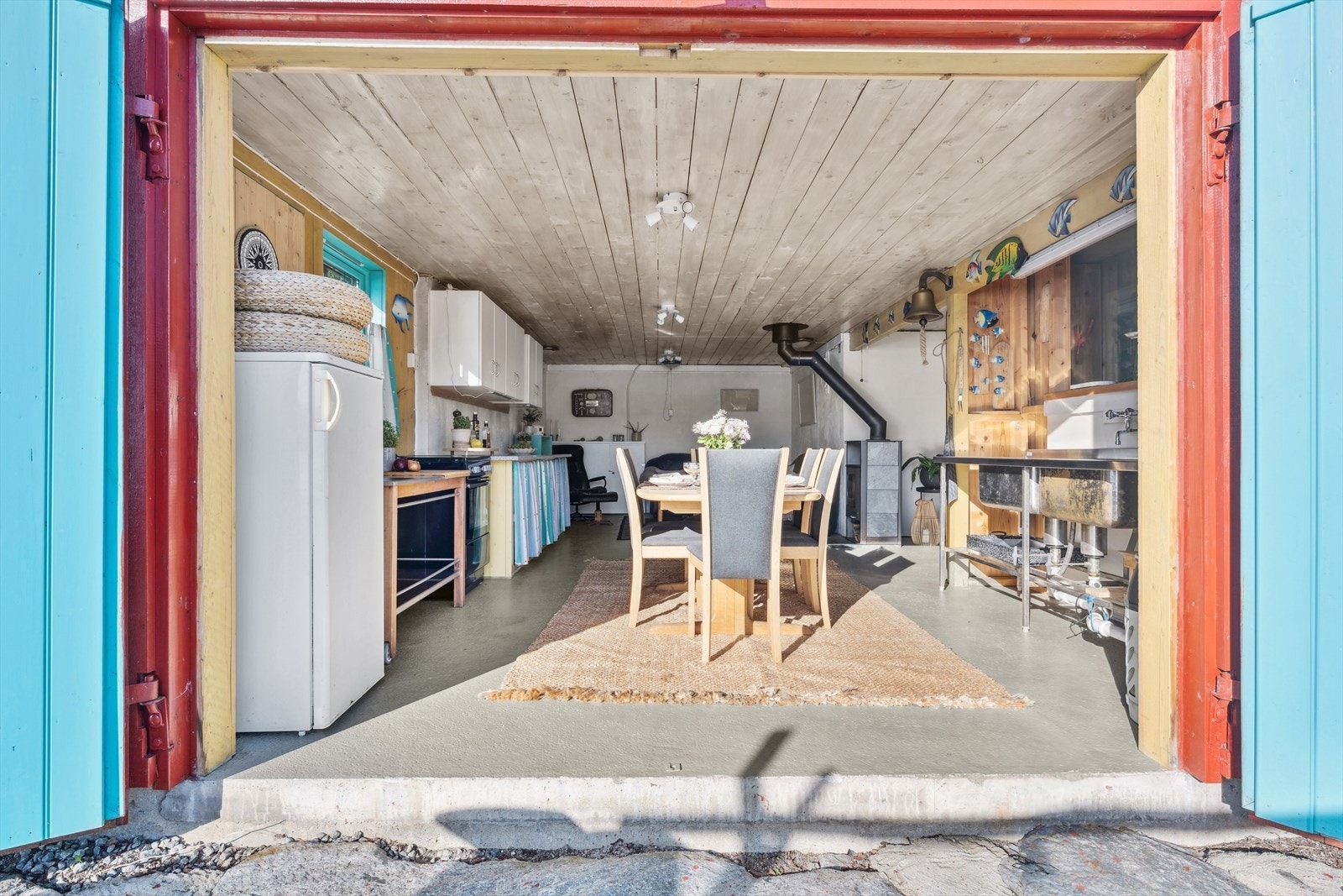 Første etasje inkluderer et kjøkken med benkeplass, skuffeplass og innlagt strøm, hvor du kan sette inn komfyr og kjøleskap. Det er god plass til et langbord for hele familien, samt en utslagsvask med innlagt kommunalt vann. Galleribilde