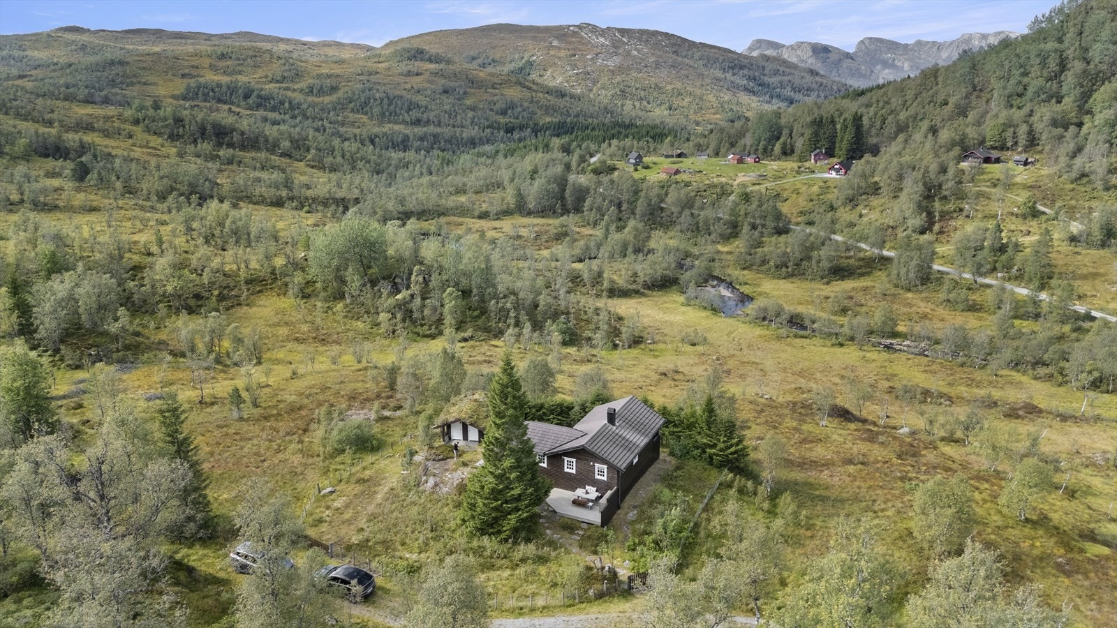 Hytta ligg på eit lite høgdedrag i dalføret, og har gode solforhold på sommaren Galleribilde