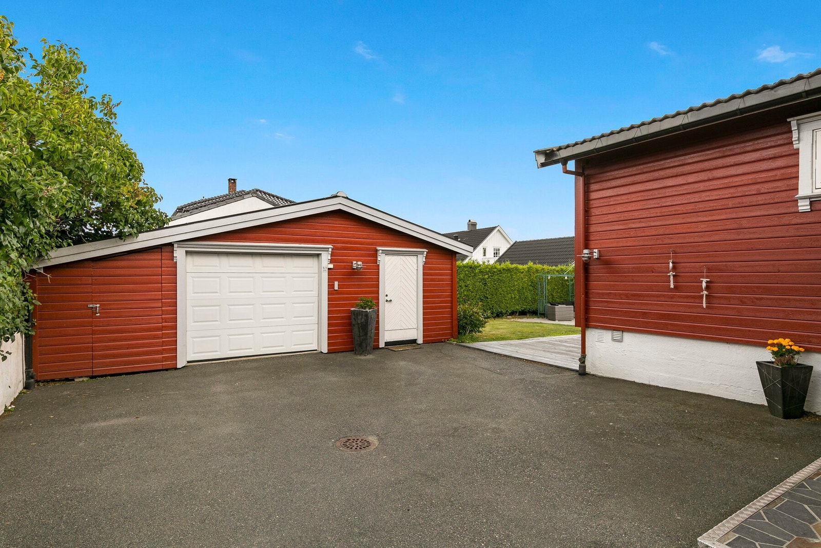 Stor og asfaltert gårdsplass med gode parkeringsmuligheter, i tillegg til stor garasje med flere rom til oppbevaring. Galleribilde