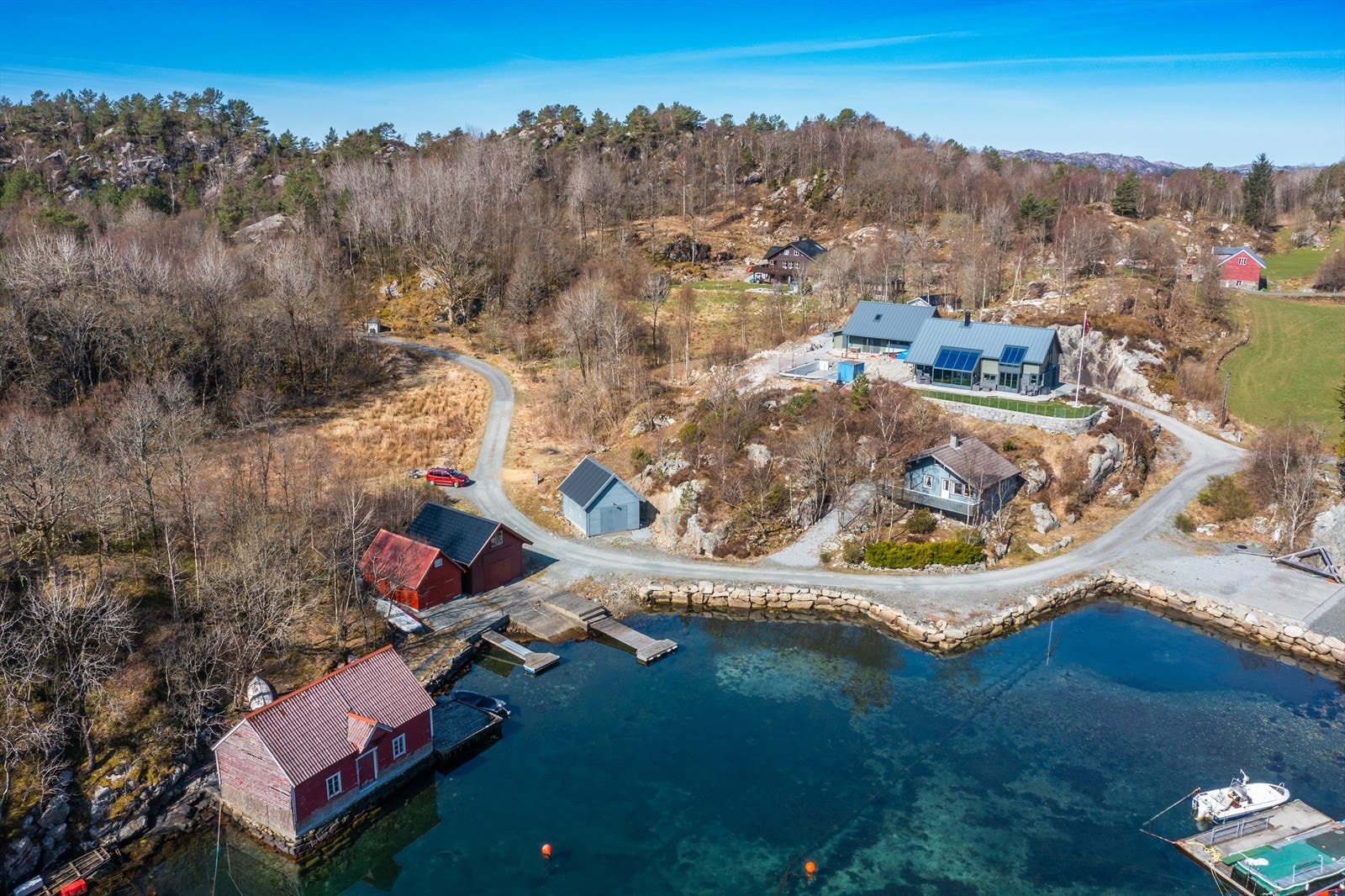 Tomten er bak og ved siden av det blå naustet Galleribilde