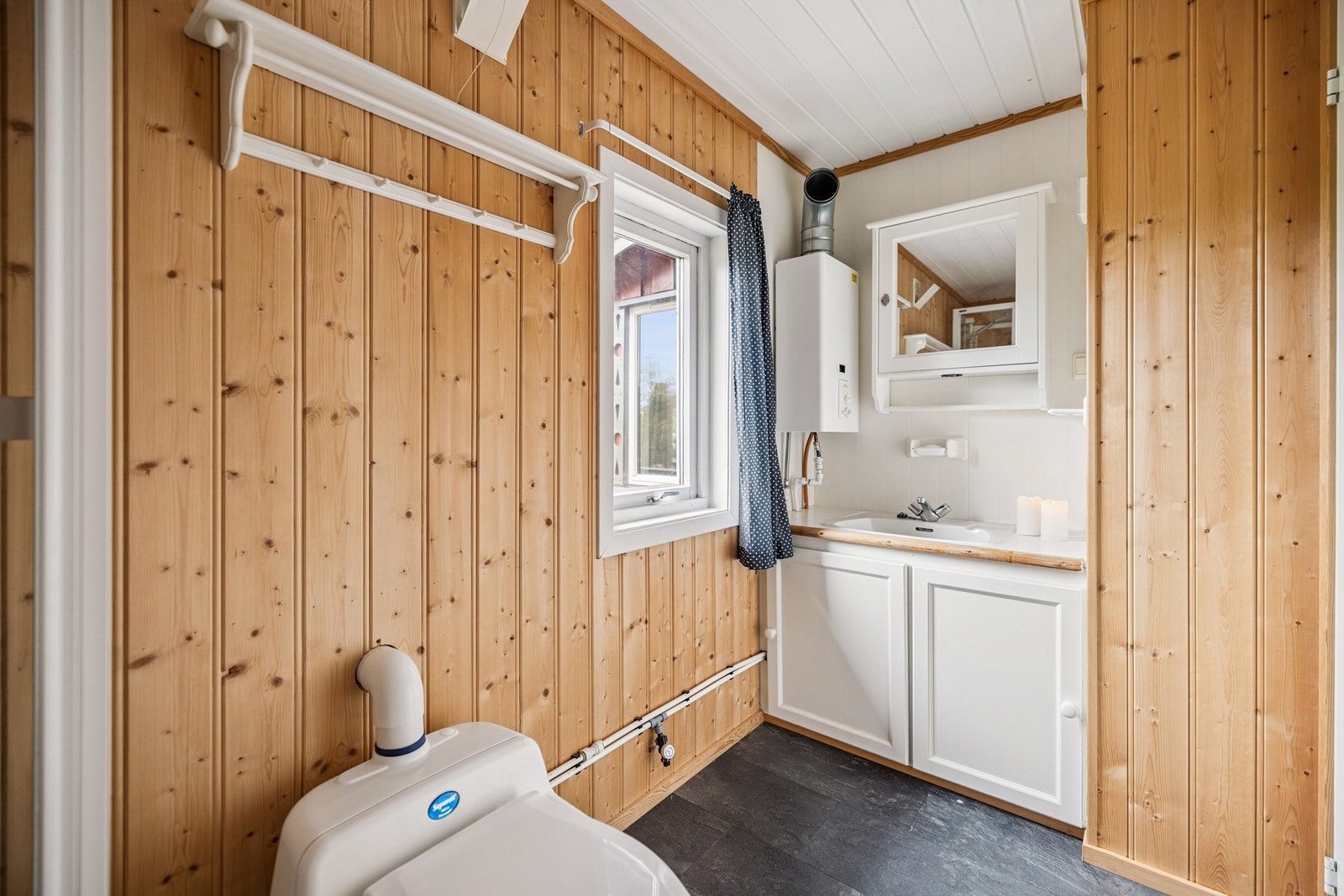 Enkel og praktisk løsning med servant og propandrevet varmtvannstank på sanitærrommet. Galleribilde