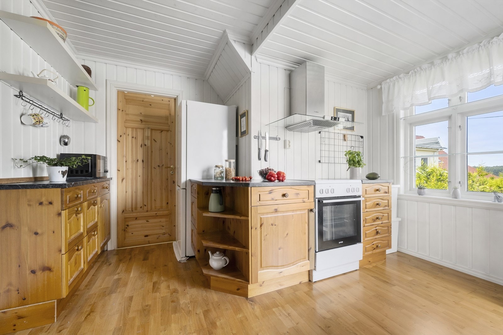 Lakkert furukjøkken i 1. etg., med laminert benkeplate. Kjøkkenet har inndelte soner for steking, matlaging og våtsone. Galleribilde